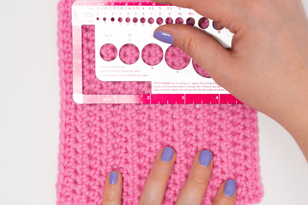 Close-up of counting stitches to measure crochet gauge