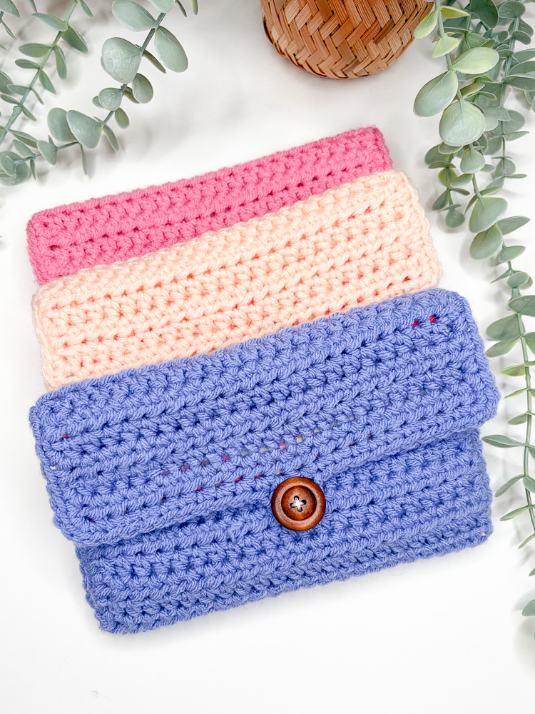 three closed crochet hook pouches arranged in a flat lay