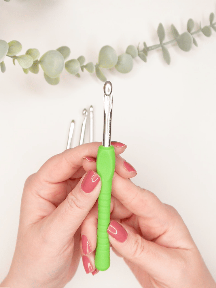 close up of hands holding a 6.0 mm ergonomic crochet hook