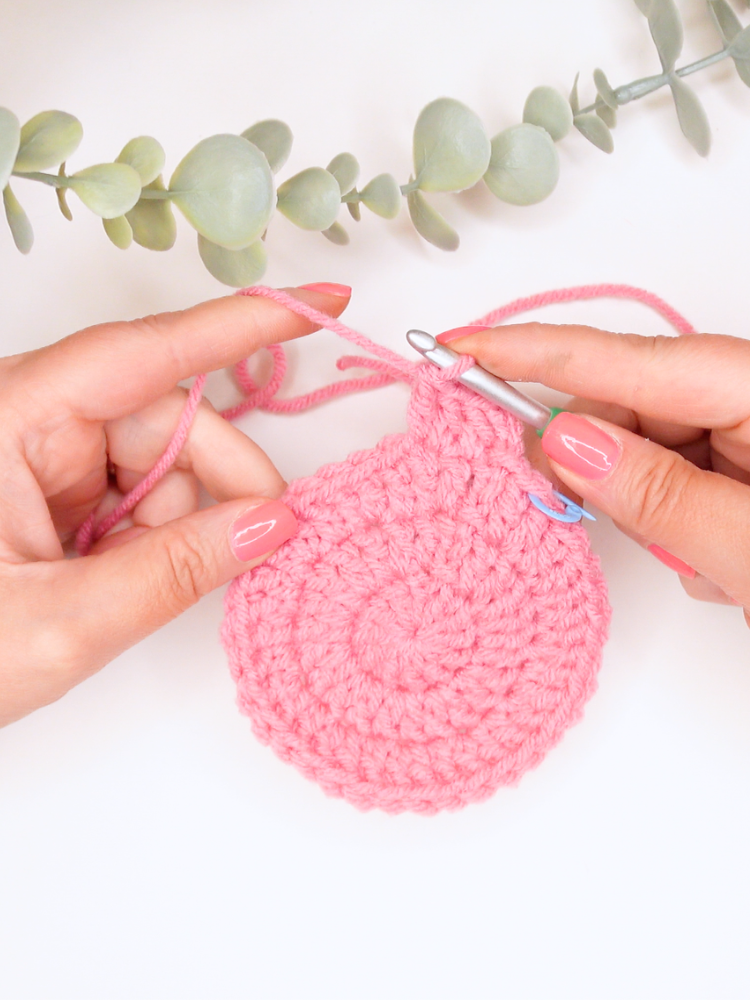 womans hands crocheting a double crochet circle